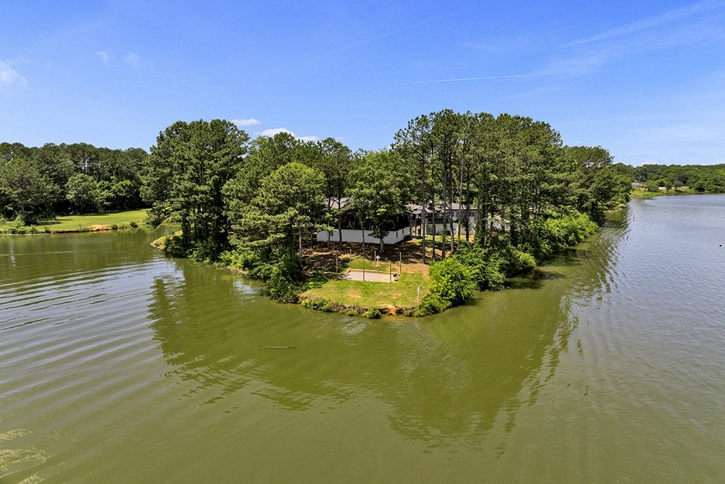 A small island with a house surrounded by water.